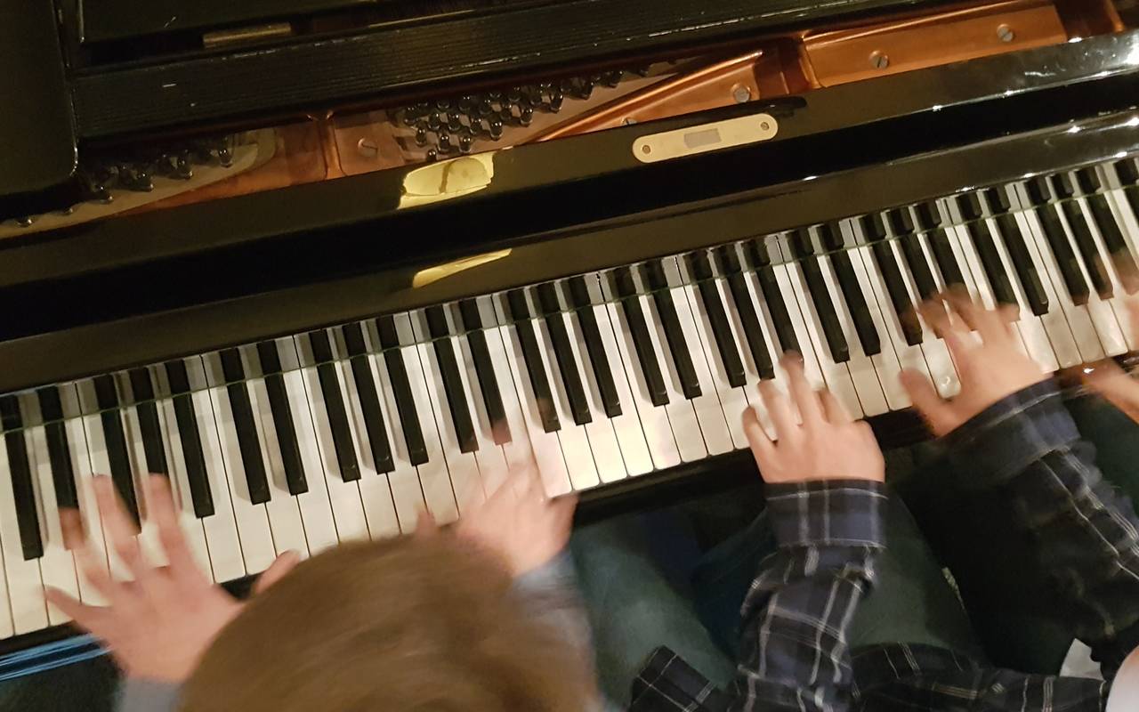Kinder spielen Klavier beim Klavierkonzert.