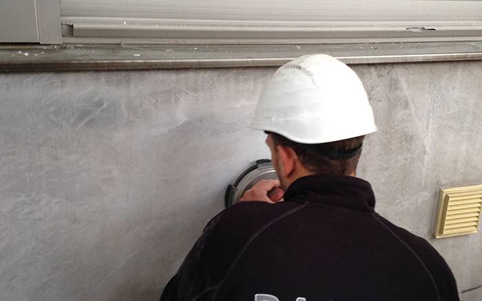 Mitarbeiter von Rasche reinigt eine Wand.