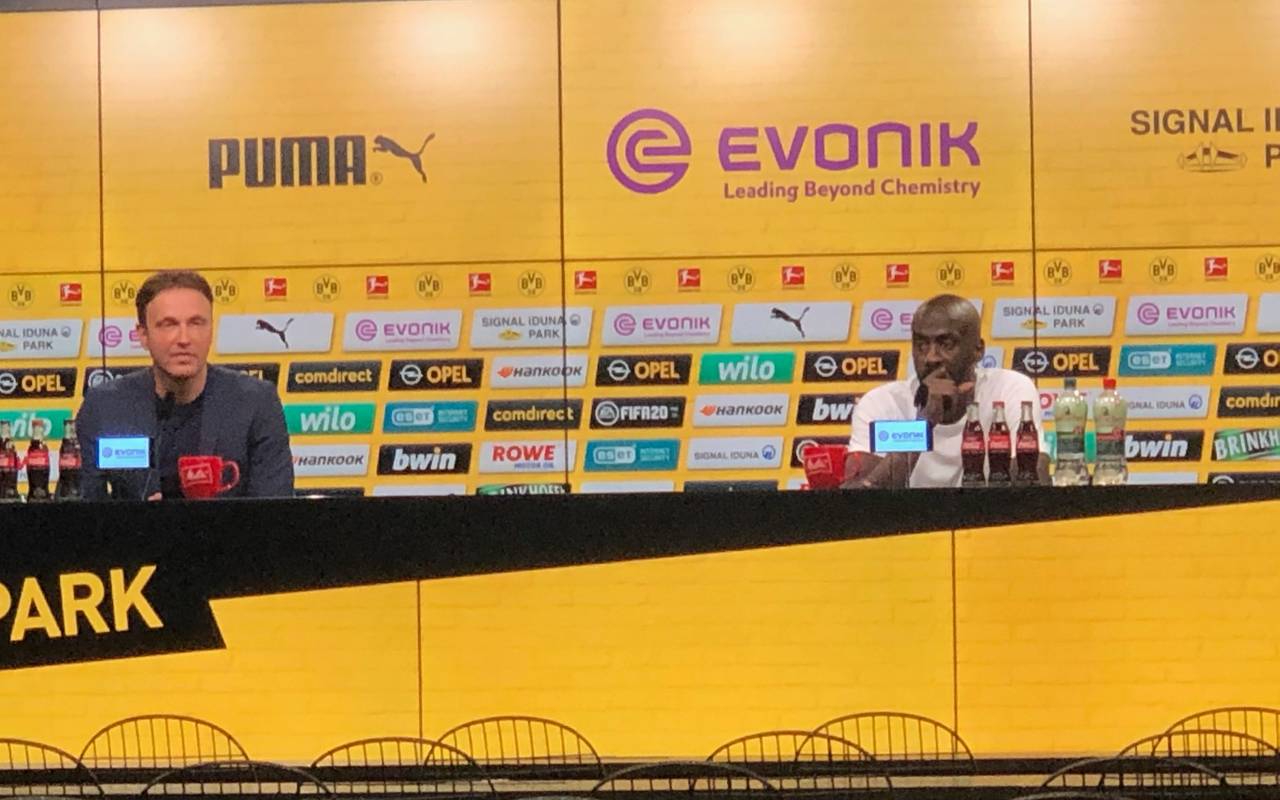 Zwei Männer sitzen hinter einem Podium.