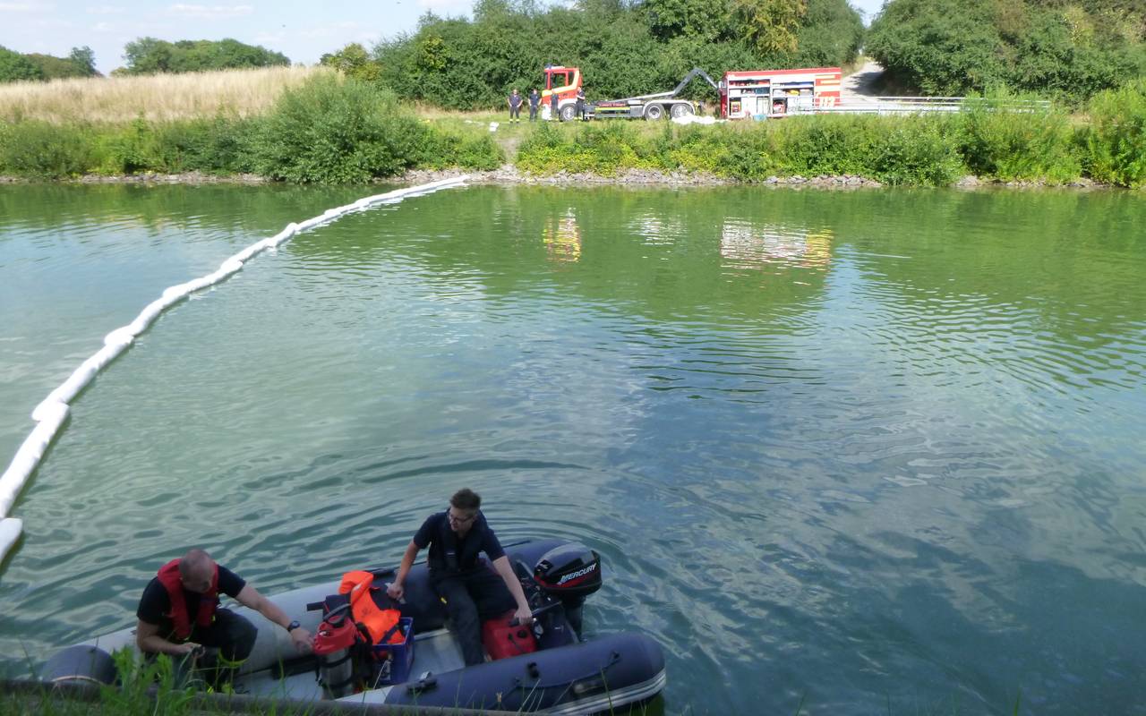 Einsatzkräfte im Schlauchboot beim Ausbringen der Ölsperren