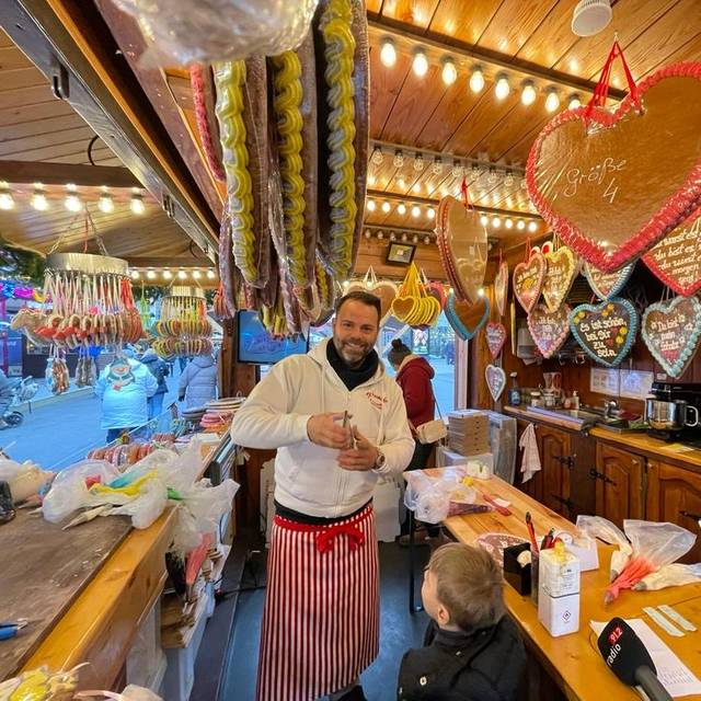 Rick Paßquali beschriftet Lebkuchenherzen auf dem Dortmunder Weihnachtsmarkt