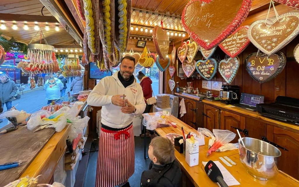 Rick Paßquali beschriftet Lebkuchenherzen auf dem Dortmunder Weihnachtsmarkt