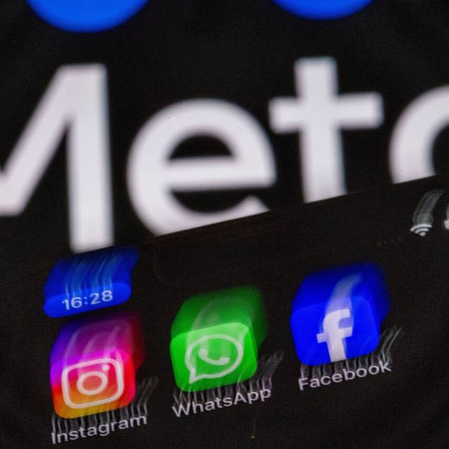 Die Apps Instagram, Facebook und WhatsApp sind auf dem Display eines Smartphones vor dem Logo des Internetkonzerns Meta zu sehen