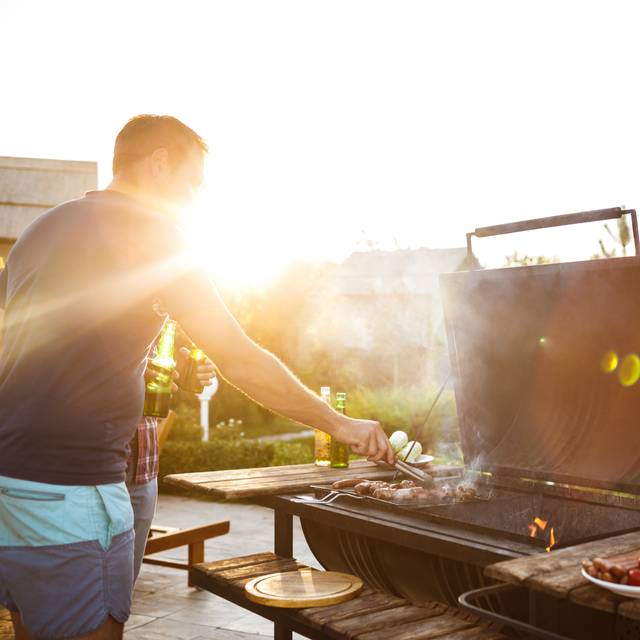 Mann grillt an Gasgrill