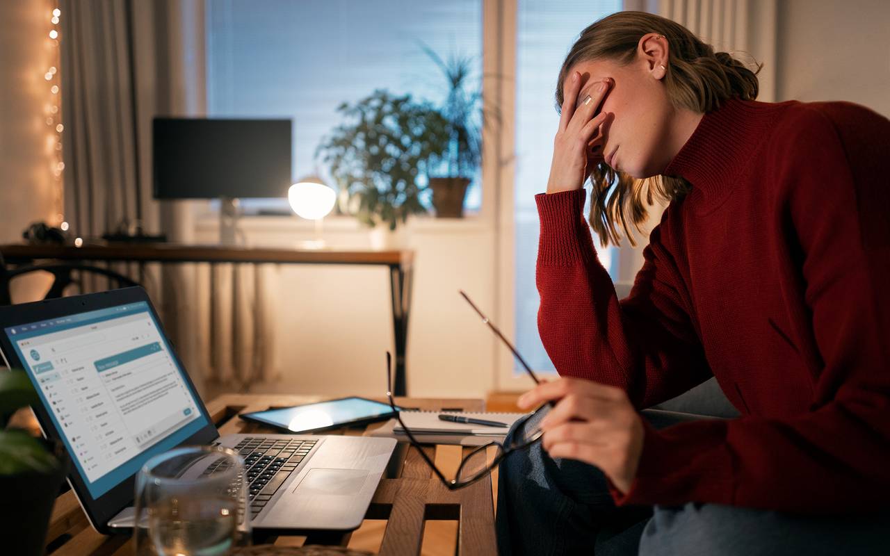 Frau sitzt spät abends am Laptop und arbeitet von zuhause