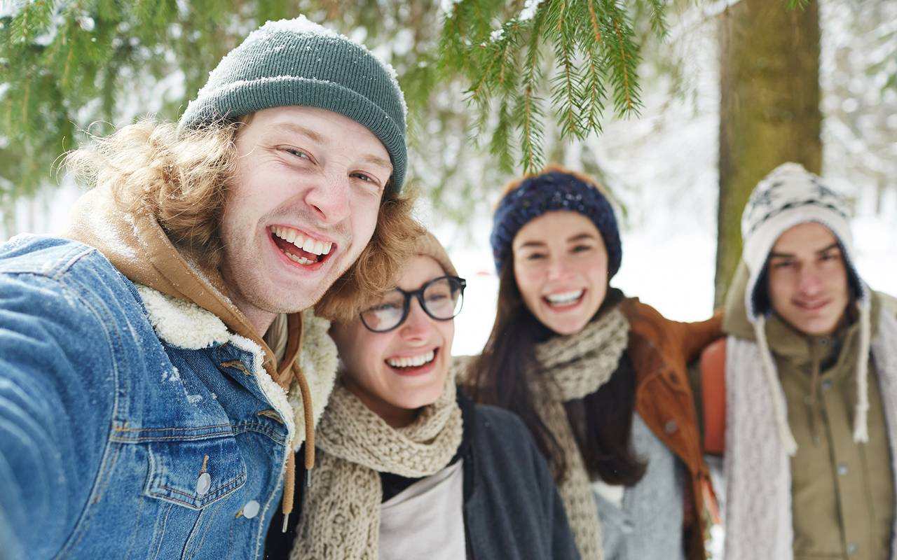 Freundesgruppe im Schnee lachen.
