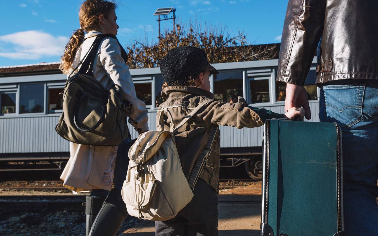 Familie am Bahnsteig mit Gepäck