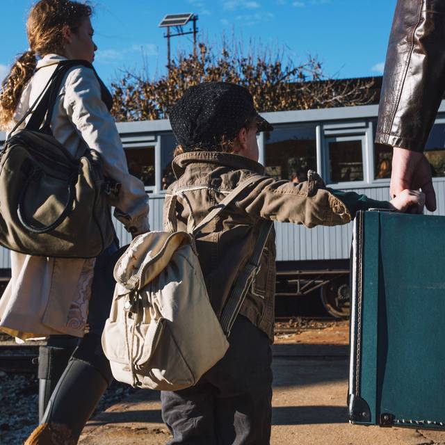 Familie am Bahnsteig mit Gepäck