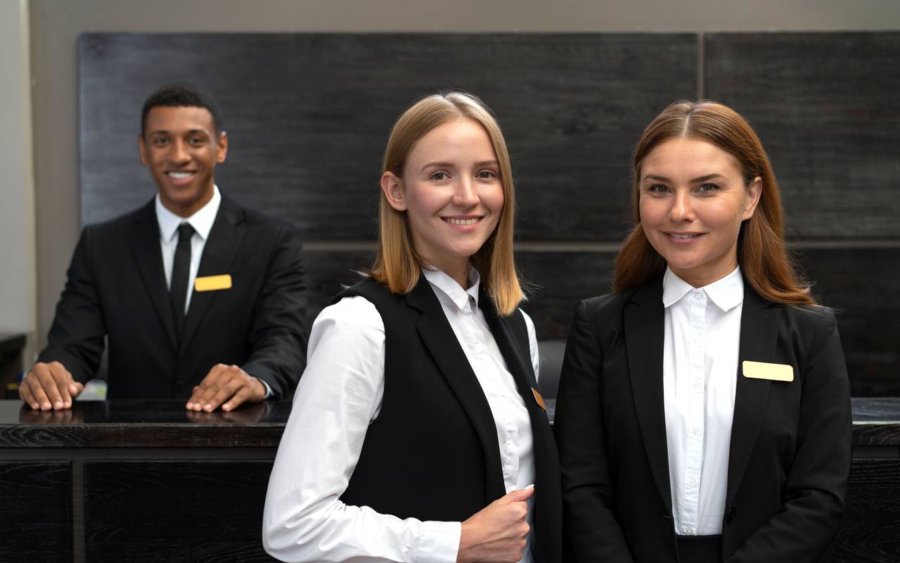 Hotelpersonal (Zwei Frauen und ein Mann am Empfang