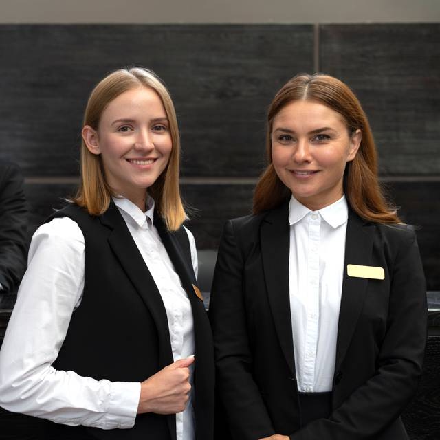 Hotelpersonal (Zwei Frauen und ein Mann am Empfang