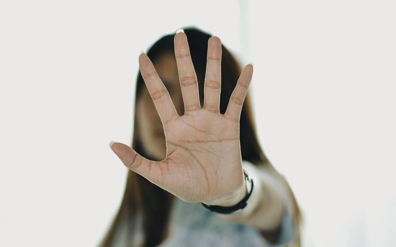 Frau streckt ihre Hand offen zur Kamera aus