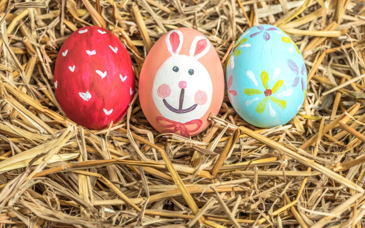 Drei bunte Ostereier im Stroh