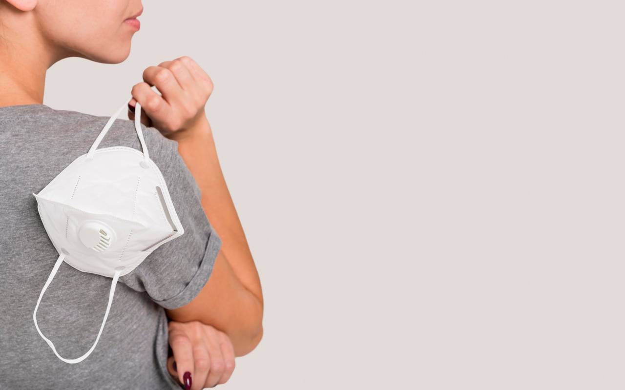 Frau hält FFP2 Maske in der Hand