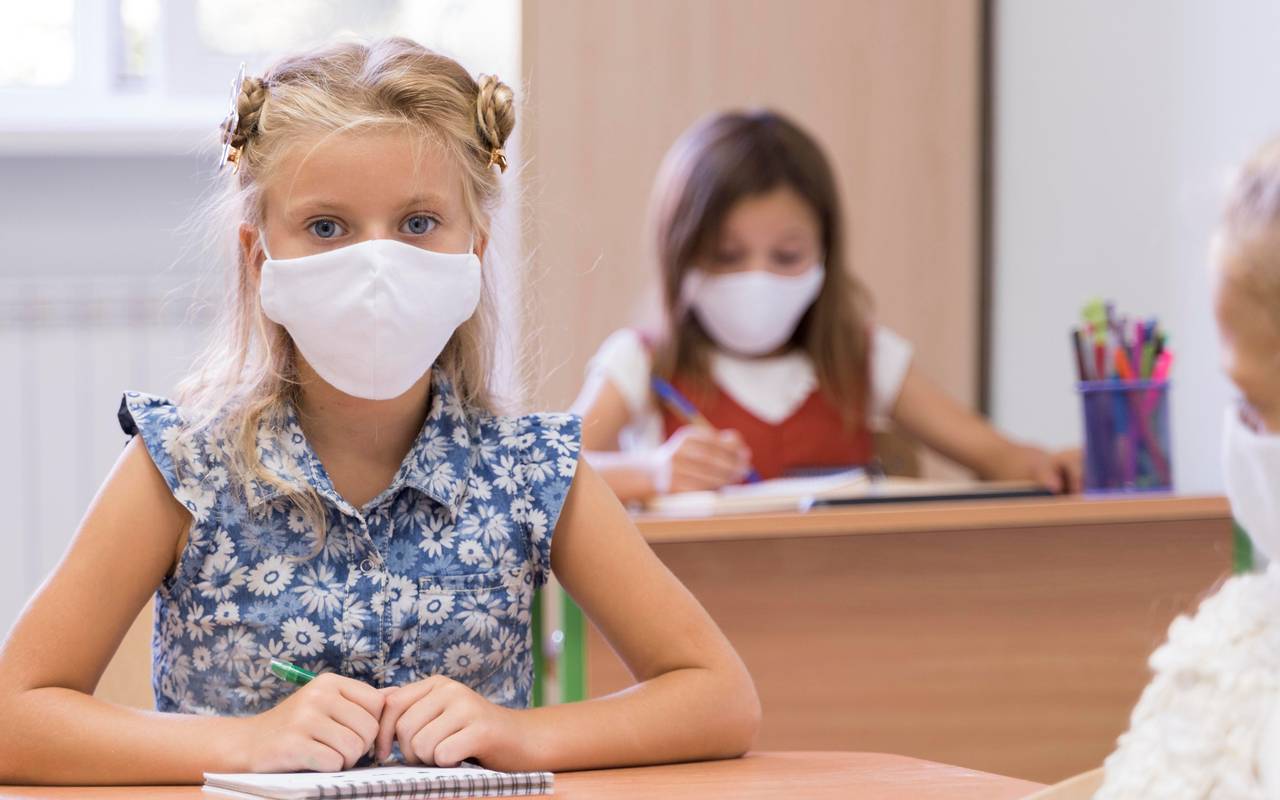 Schülerinnen tragen Masken im Klassenzimmer