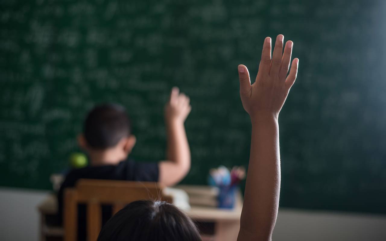 Kinder melden sich im Klassenzimmer