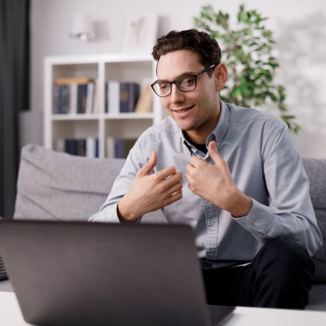 Mann telefoniert auf seinem Laptop per Videochat