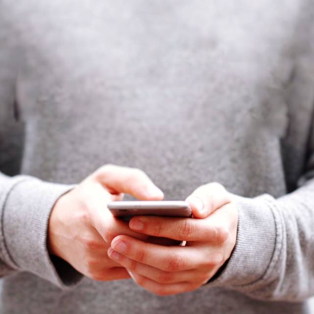 Eine Person hält ein Smartphone in der Hand