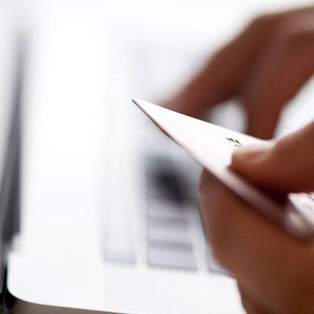 Eine Person mit Kreditkarte und Laptop