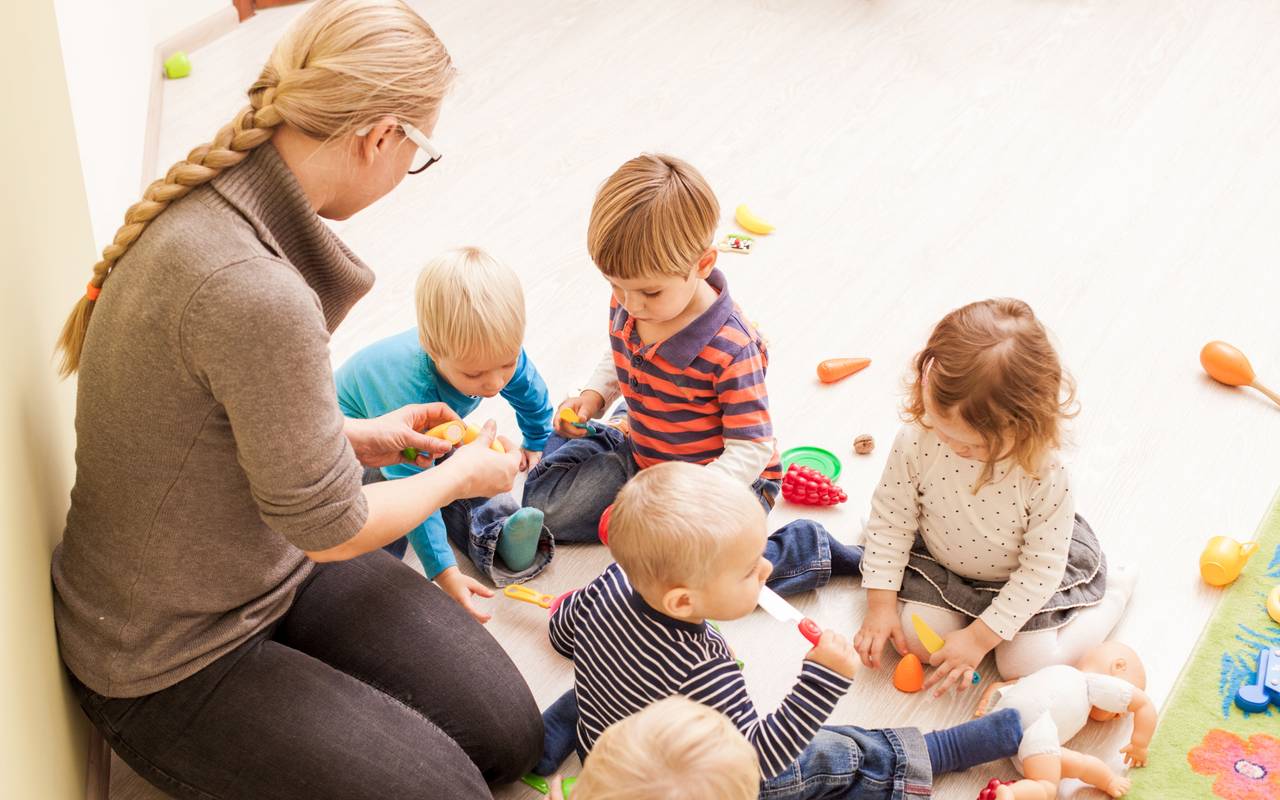 Eine frau spielt mit vier kleinen Kindern