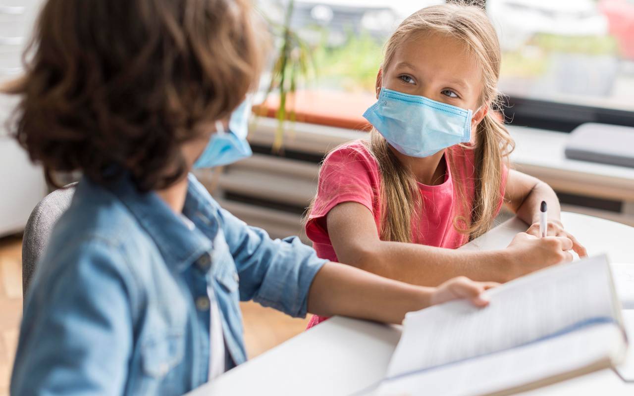 Zwei Schüler tragen eine Maske in der Klasse