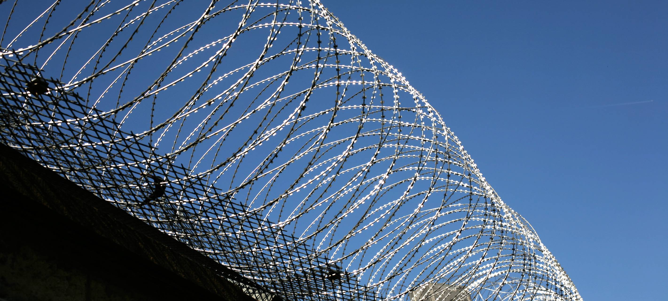 Stacheldraht um Gefängnis (Symbolbild)