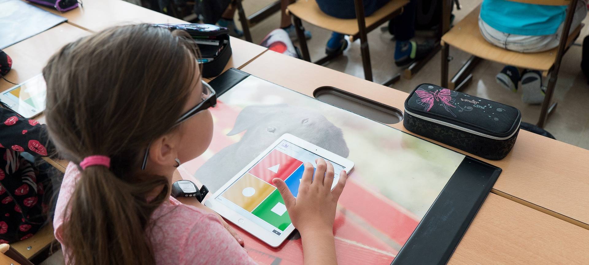 Mädchen nutzt Tablet in der Schule.
