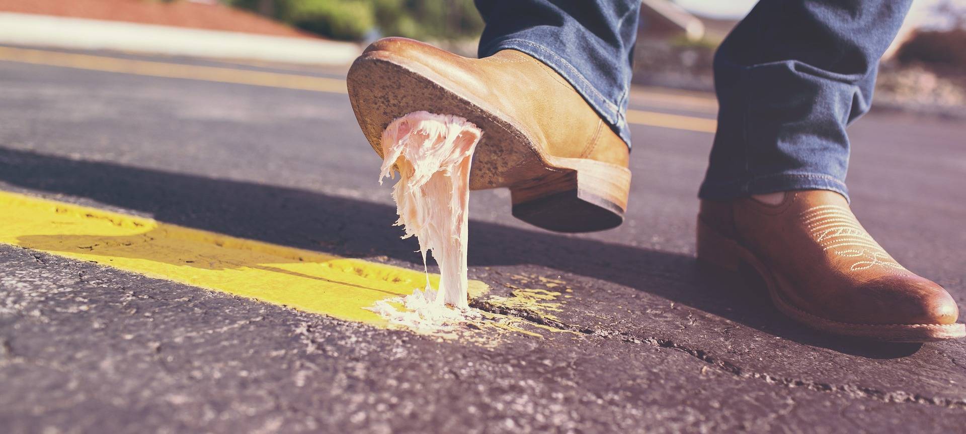 Mann tritt auf der Straße in ein Kaugummi (Symbolbild)