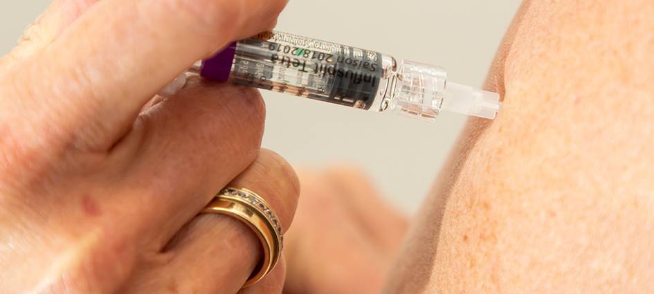 Impfung wird in den Arm gegeben.