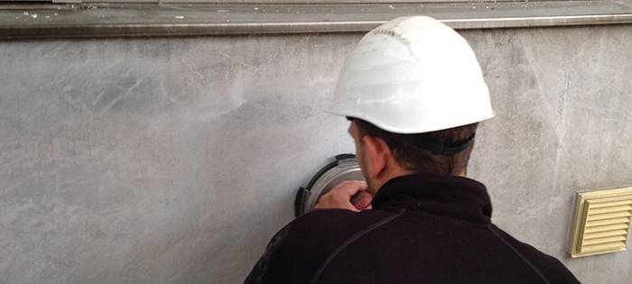 Mitarbeiter von Rasche reinigt eine Wand.