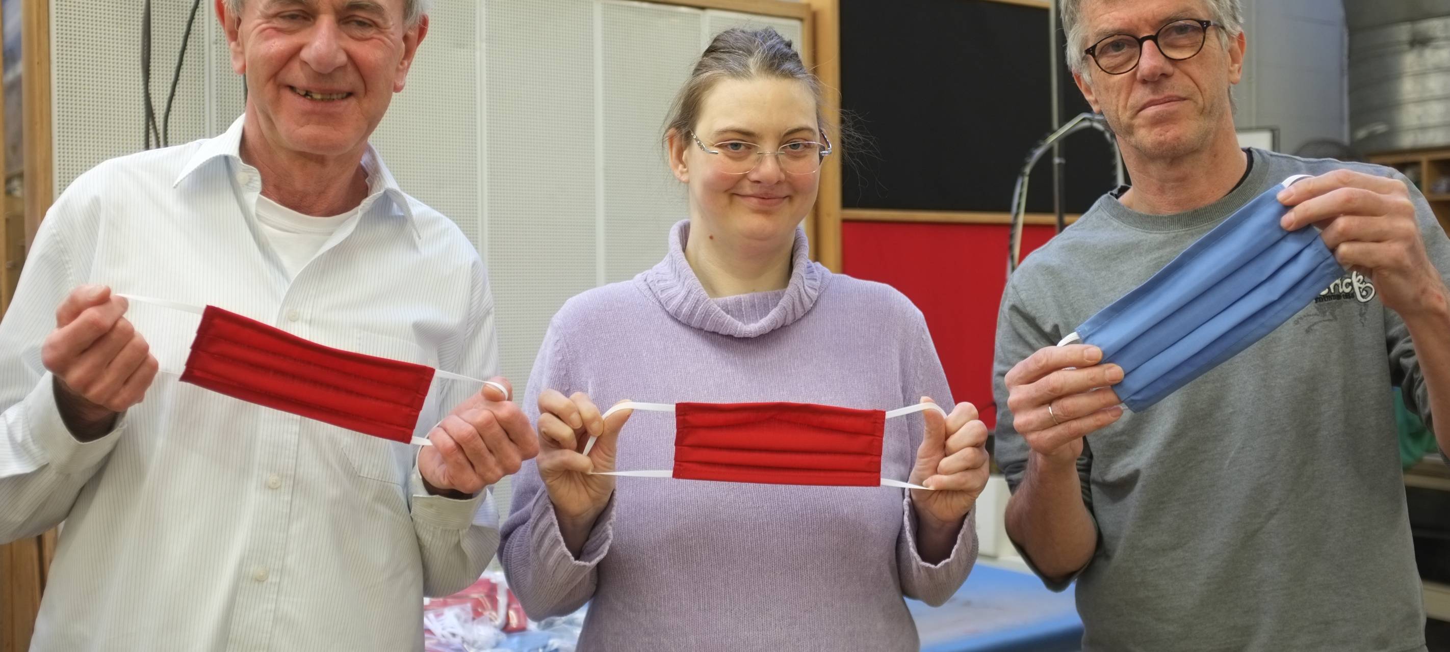 Es halten die Masken hoch: (v. l.) Dr. Klaus Hermansen, Nicole Bugaj und Bernhard Eichhorn, Leiter der Nähwerkstatt, in den Werkstätten der AWO in Dortmund.