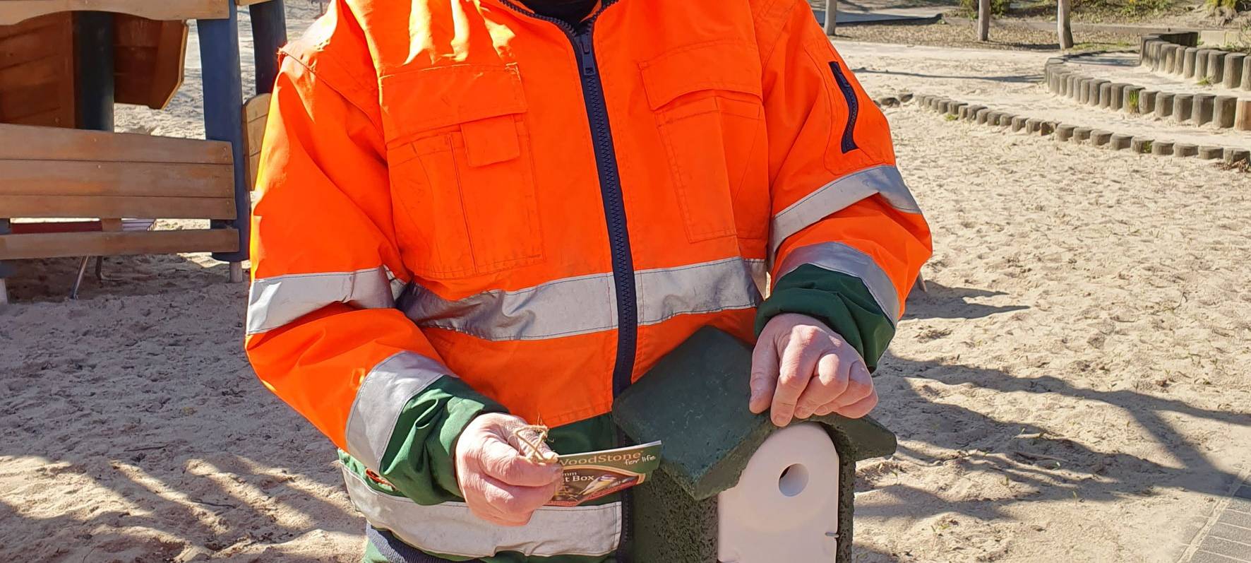 Mitarbeiter des Grünflächenamtes hängen Nistkästen für Kohlmeisen auf.