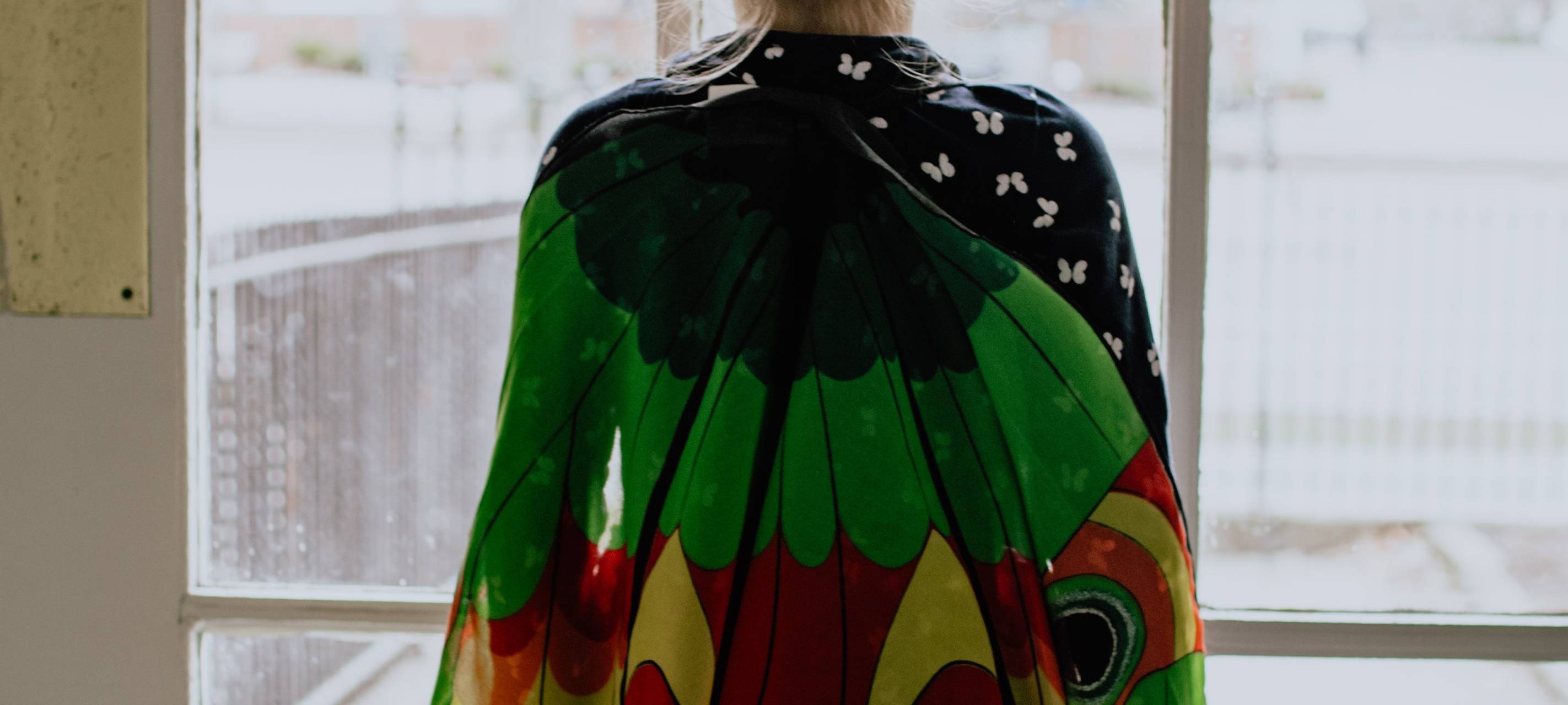 Junges Mädchen schaut aus dem Fenster. Symbolbild.