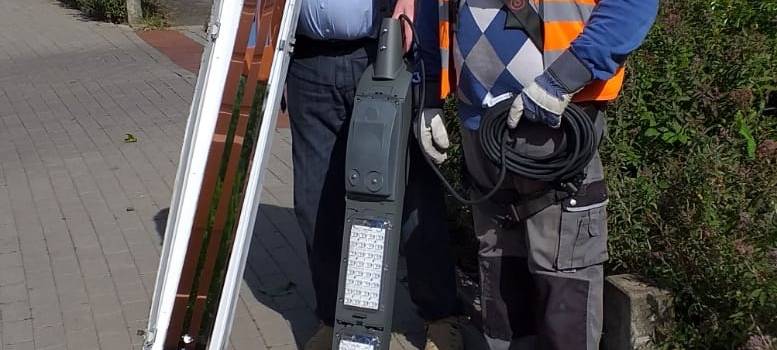 Bezirksbürgermeister Hans Semmler vor der Kapelle des Marienhospital an der Gablonzstraße und einem Firmenmitarbeiter mit der alten und der neuen Leuchte.