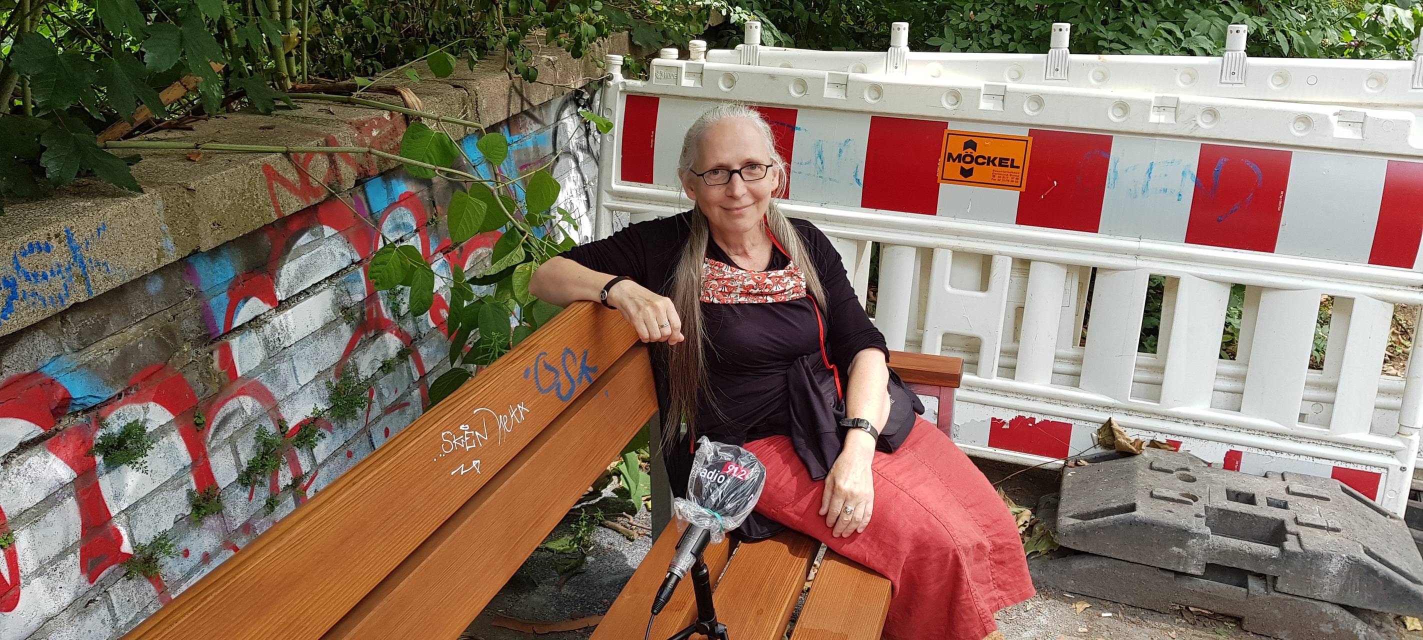 Marie Wolf auf einer neuen Sitzbank im Kreuzviertel. Pilotprojekt "Jeder Straße ihre Sitzbank"