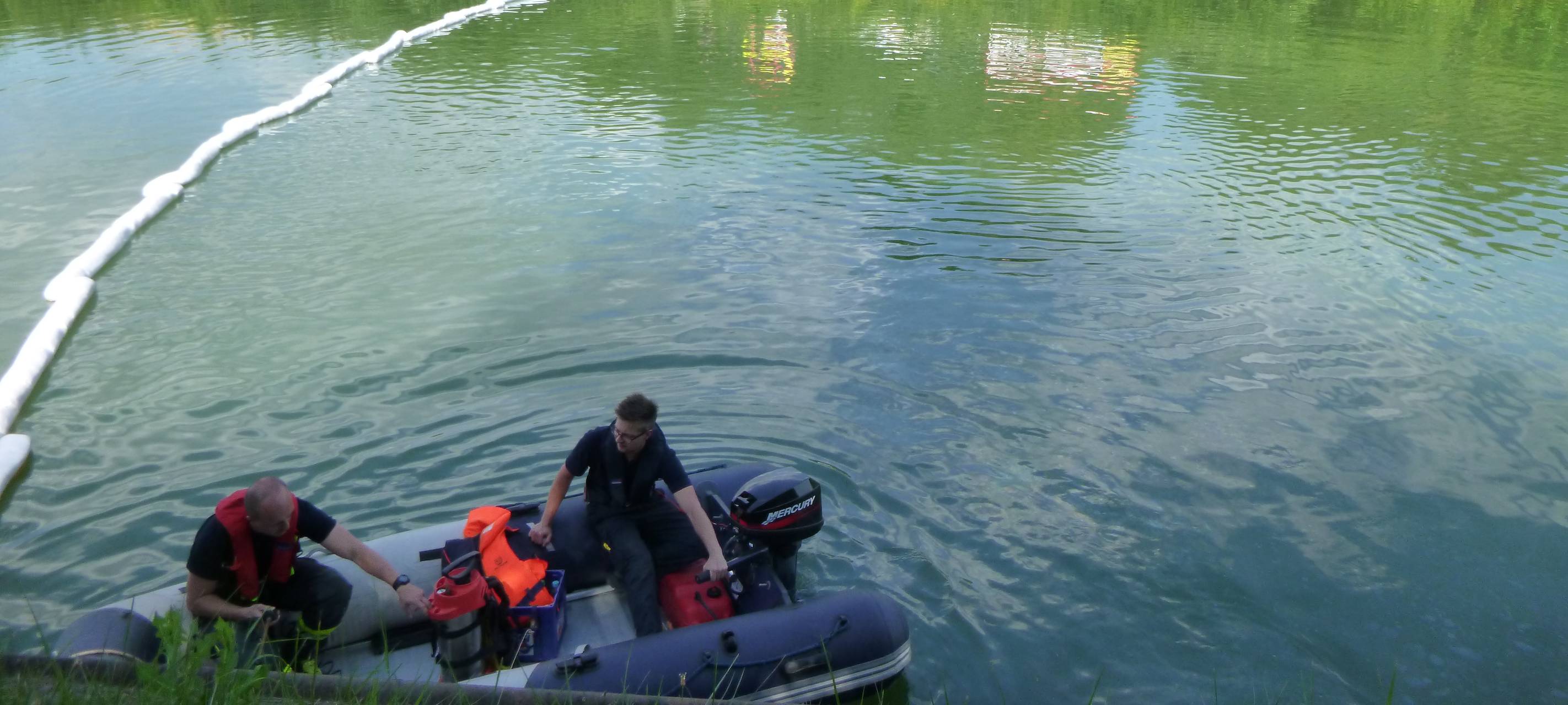 Einsatzkräfte im Schlauchboot beim Ausbringen der Ölsperren