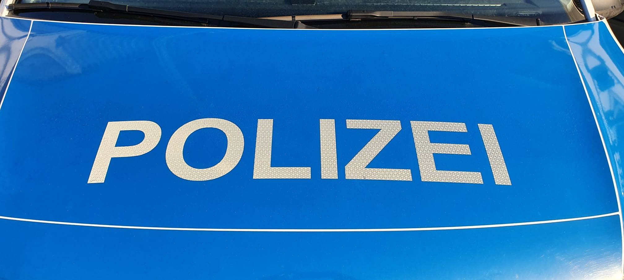 Ein Symbolbild für die Bundespolizei, wo eine blaue Motorhaube mit der Aufschrift "Polizei" zu lesen ist.
