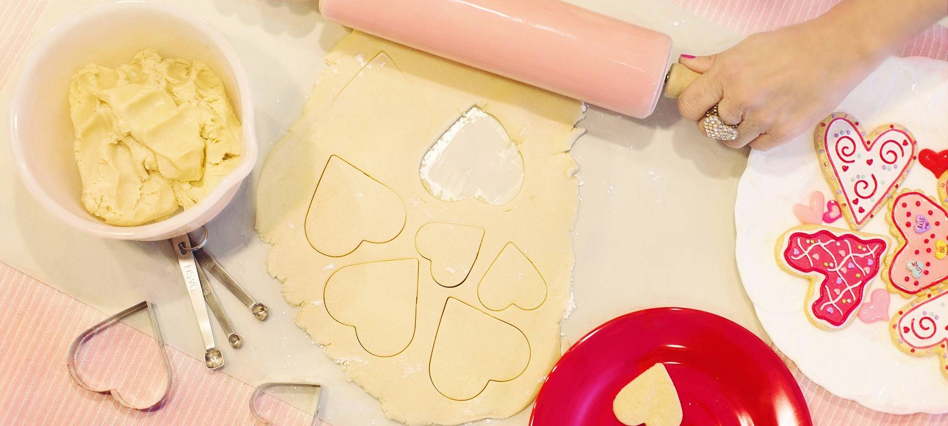 Kekse Backen: Roher Keksteig mit Ausstecher für Plätzchen in Herzform und Nudelholz