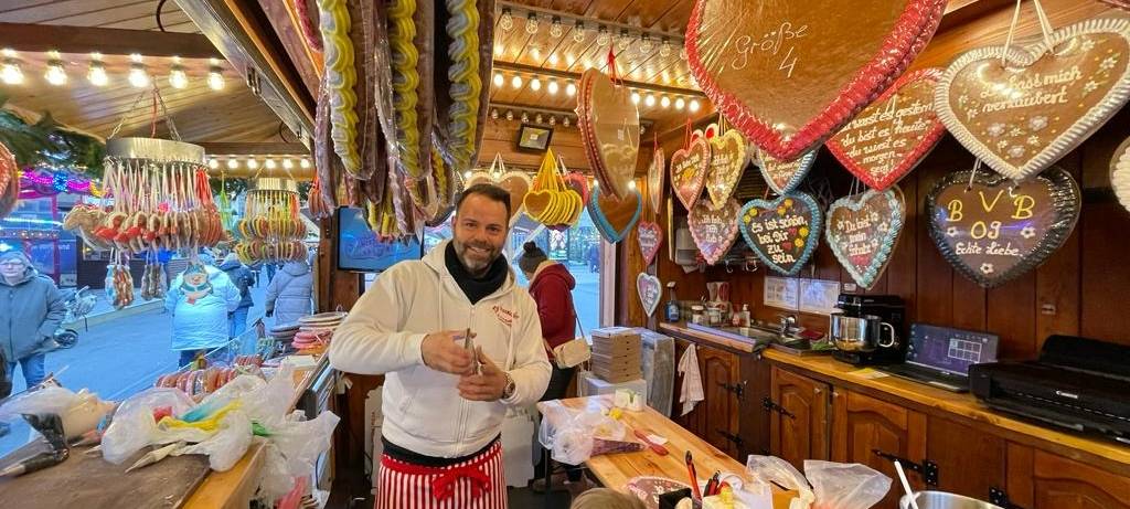 Rick Paßquali beschriftet Lebkuchenherzen auf dem Dortmunder Weihnachtsmarkt