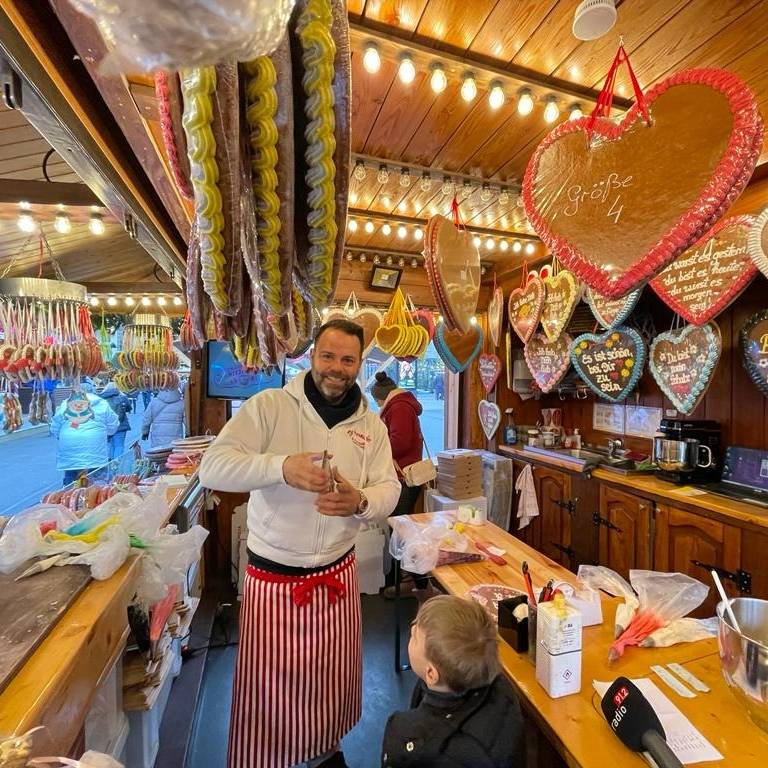 Rick Paßquali beschriftet Lebkuchenherzen auf dem Dortmunder Weihnachtsmarkt