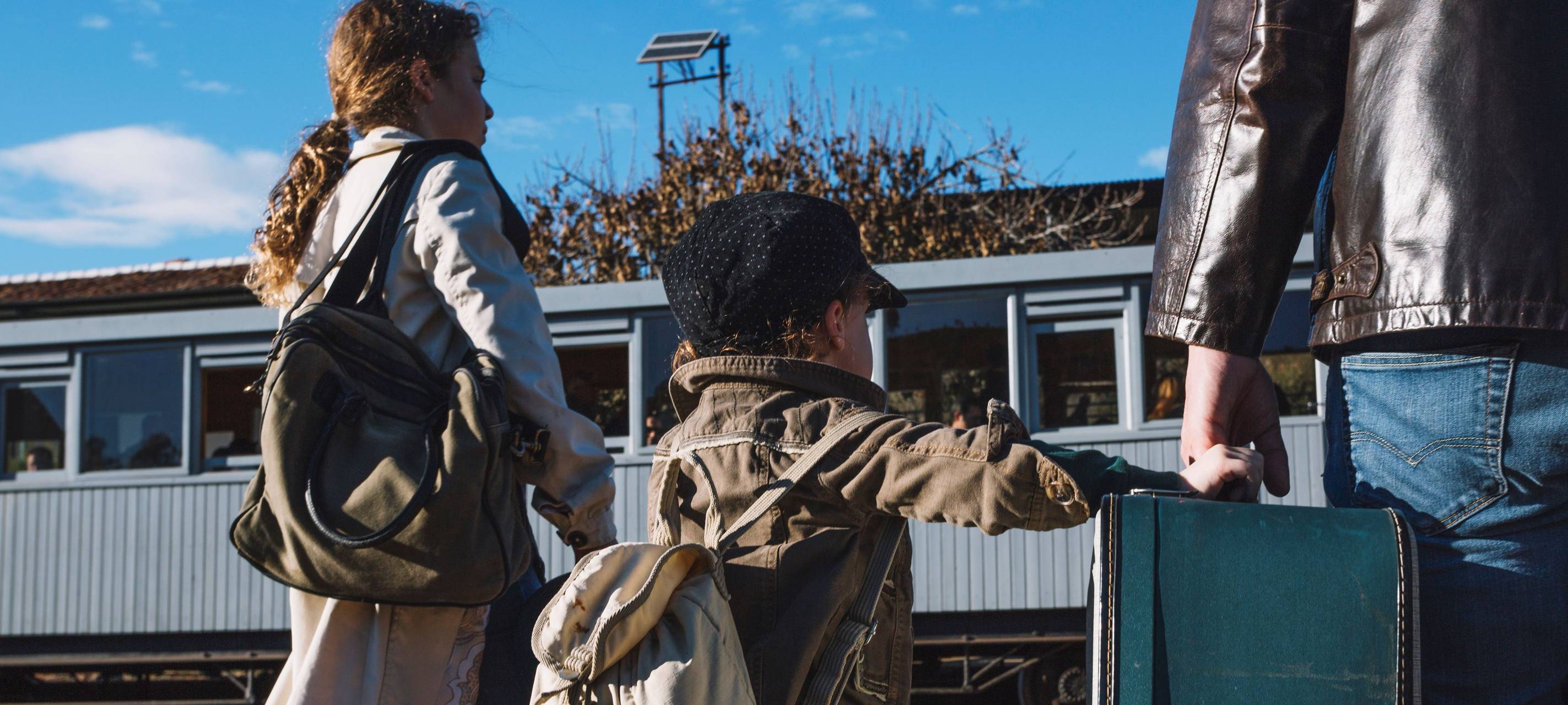 Familie am Bahnsteig mit Gepäck