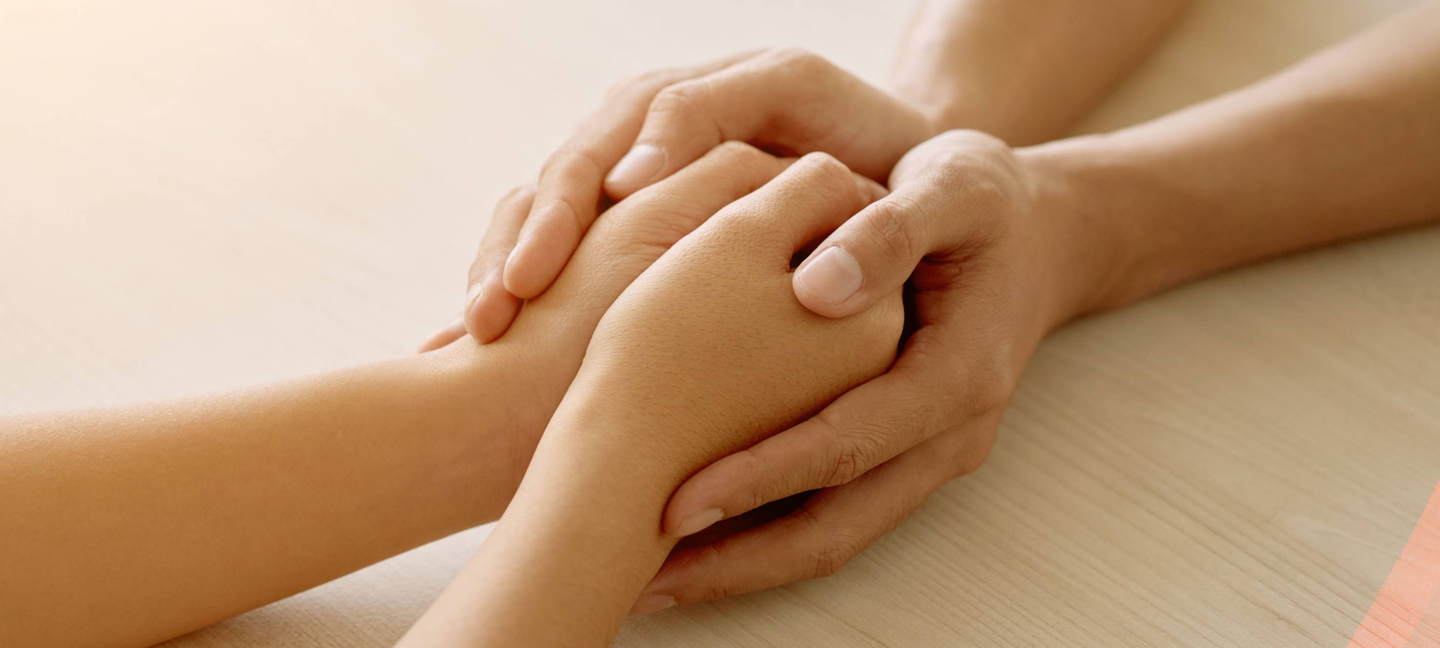 Zwei Menschen halten sich an beiden Händen