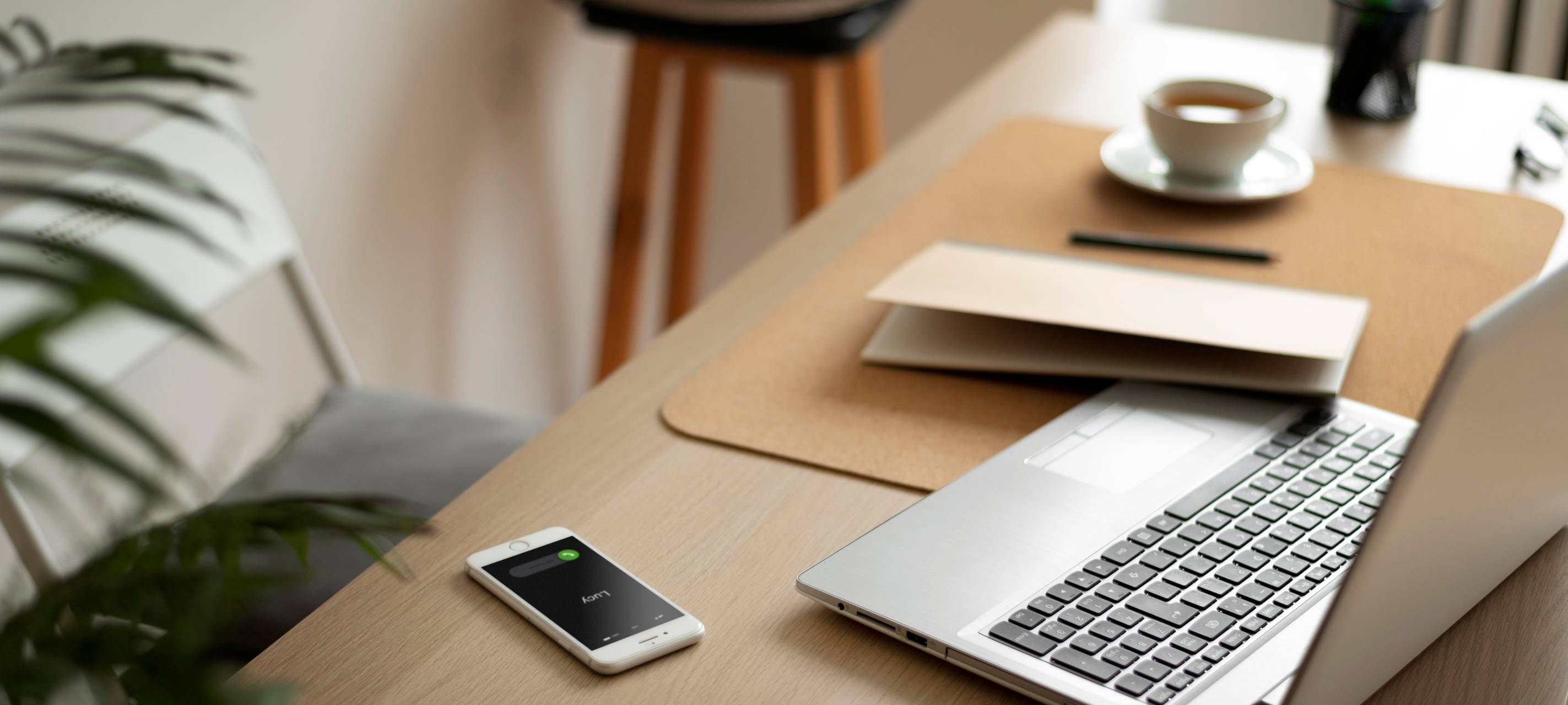 Schreibtisch mit Laptop, Handy und Unterlagen