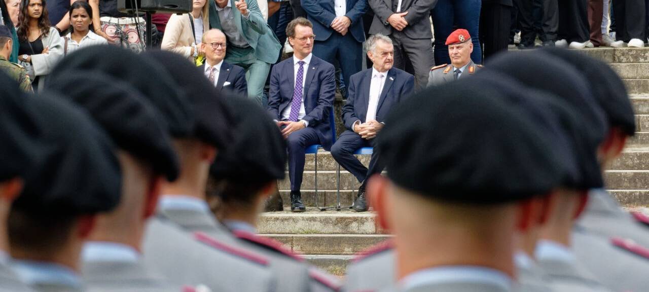 André Kuper (CDU, hinten, l-r), Präsident des Landtags von Nordrhein-Westfalen, Hendrik Wüst (CDU), Ministerpräsident von Nordrhein-Westfalen, Herbert Reul (CDU), Innenmister von Nordrhein-Westfalen, und Brigadegeneral Hans-Dieter Müller verfolgen das Gelöbnis. Rund 420 Rekruten der Bundeswehr geloben vor dem Landtag in der nordrhein-westfälischen Landeshauptstadt ihren Fahneneid.