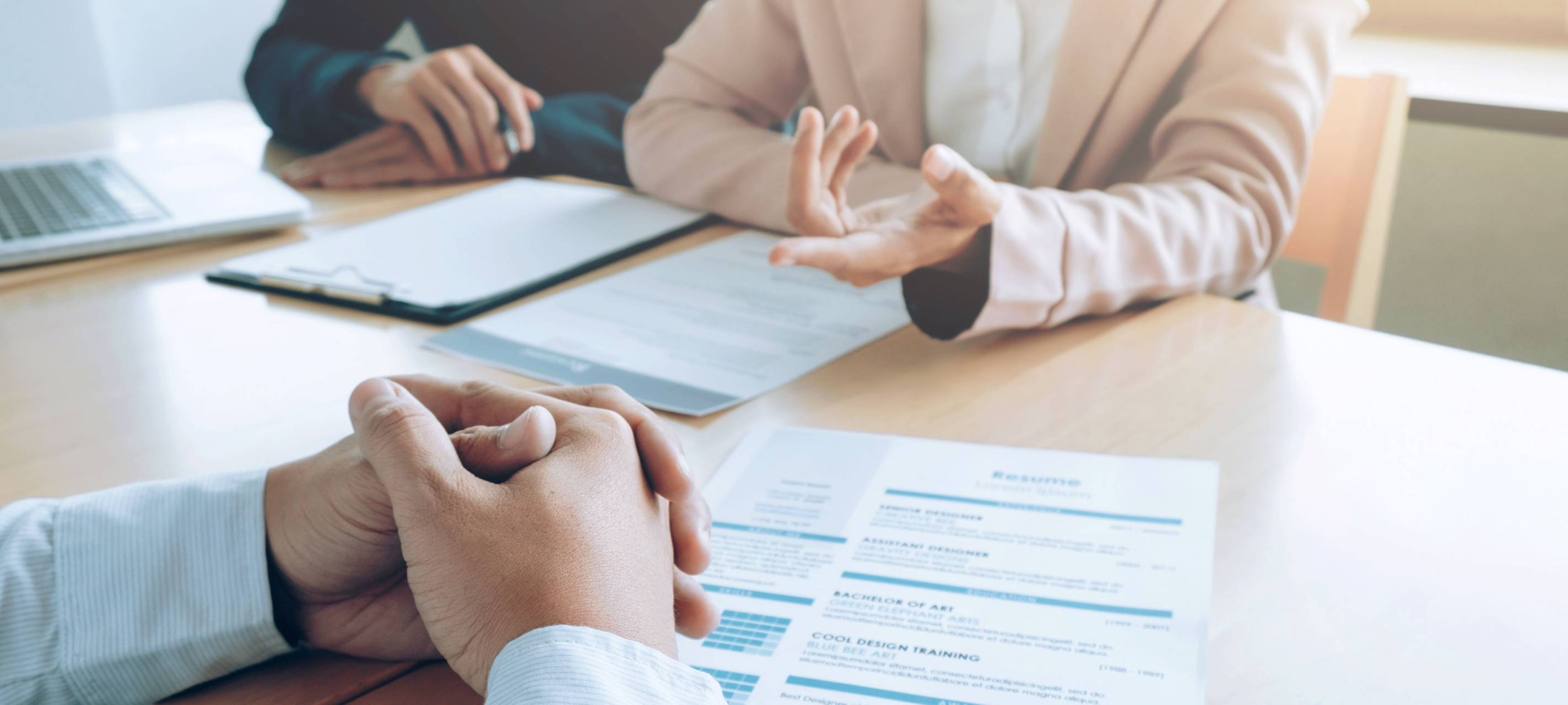 Ein Mann sitzt gegenüber von zwei Personen bei einem Bewerbungsgespräch