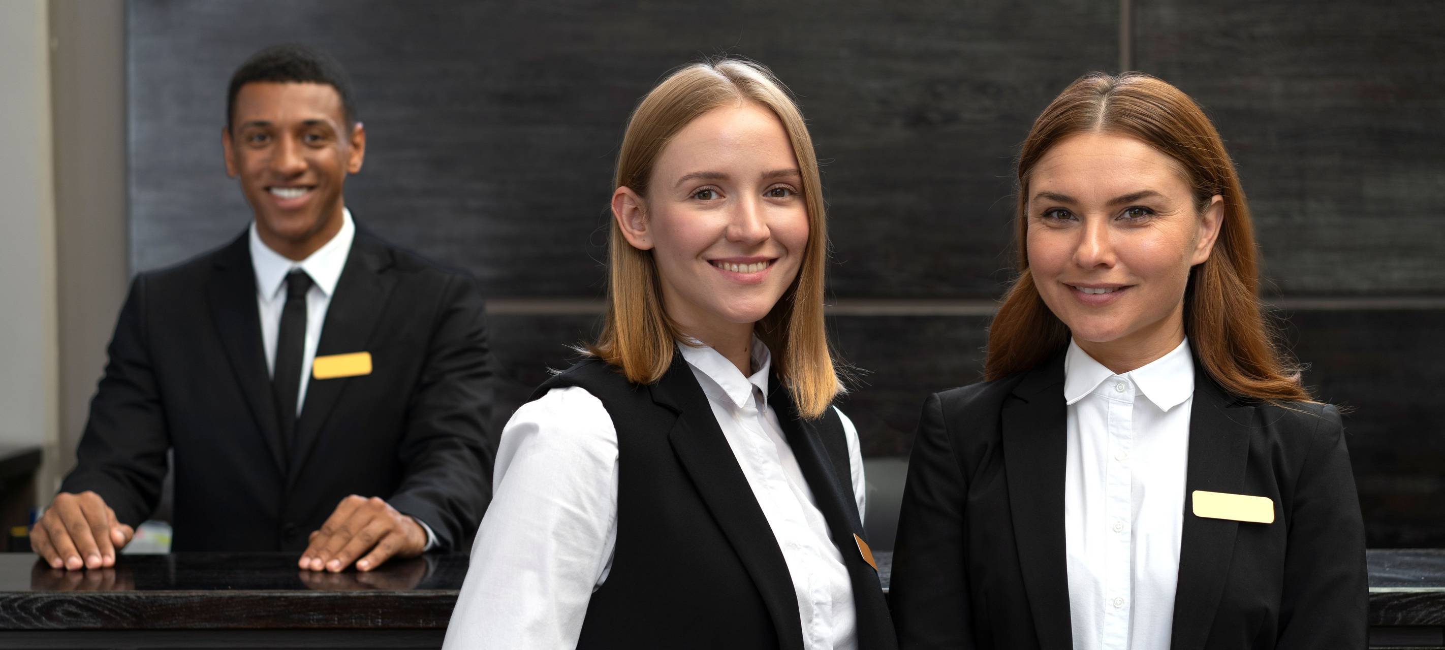 Hotelpersonal (Zwei Frauen und ein Mann am Empfang