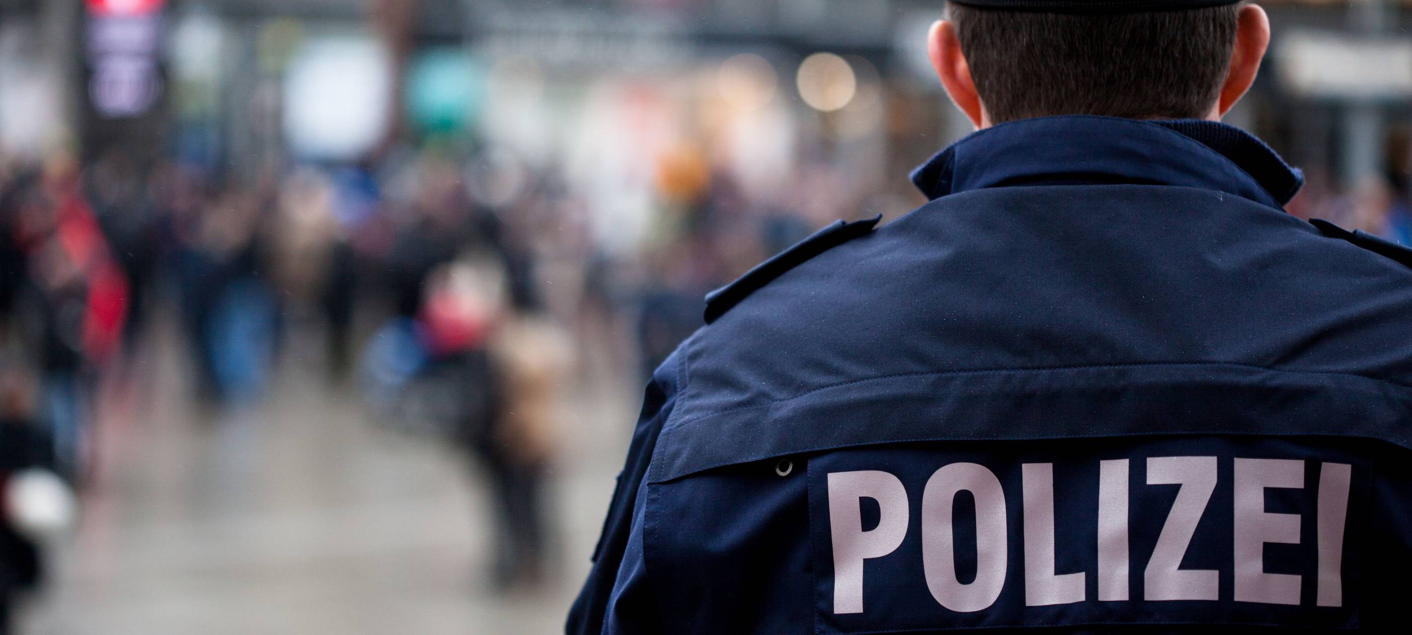 Polizist mit Polizeijacke von hinten