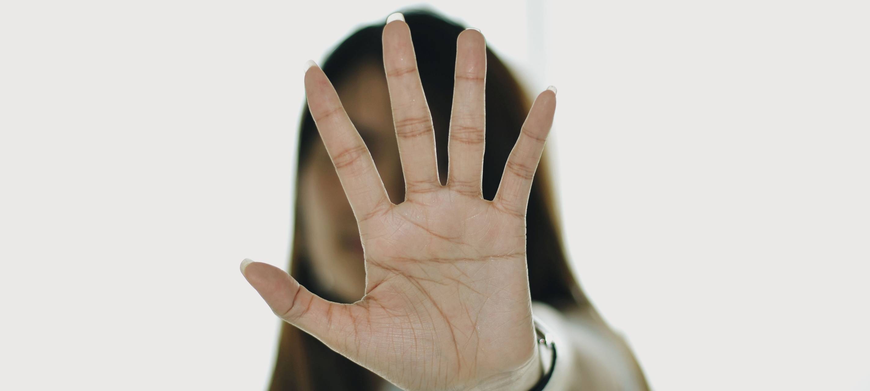 Frau streckt ihre Hand offen zur Kamera aus