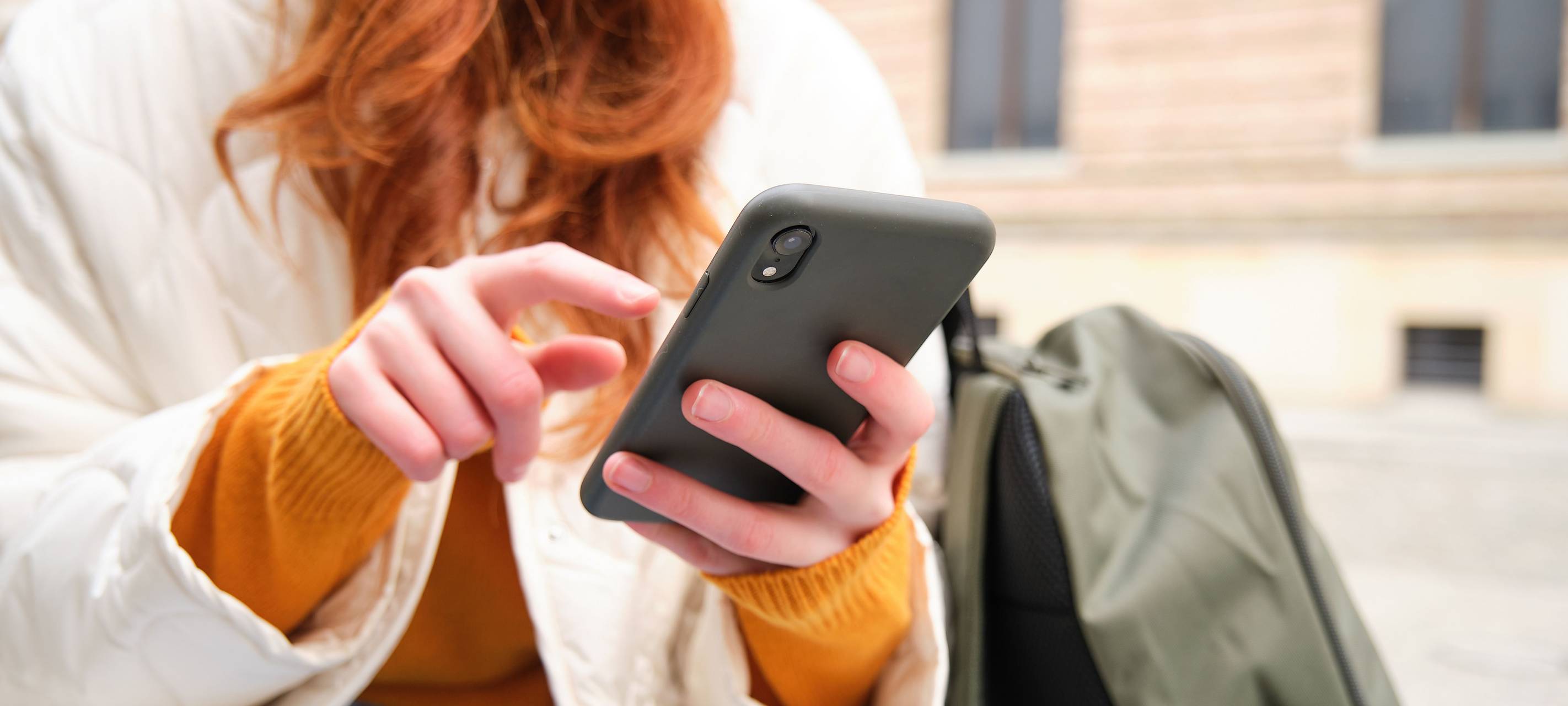 Frau tippt auf ihrem Handy