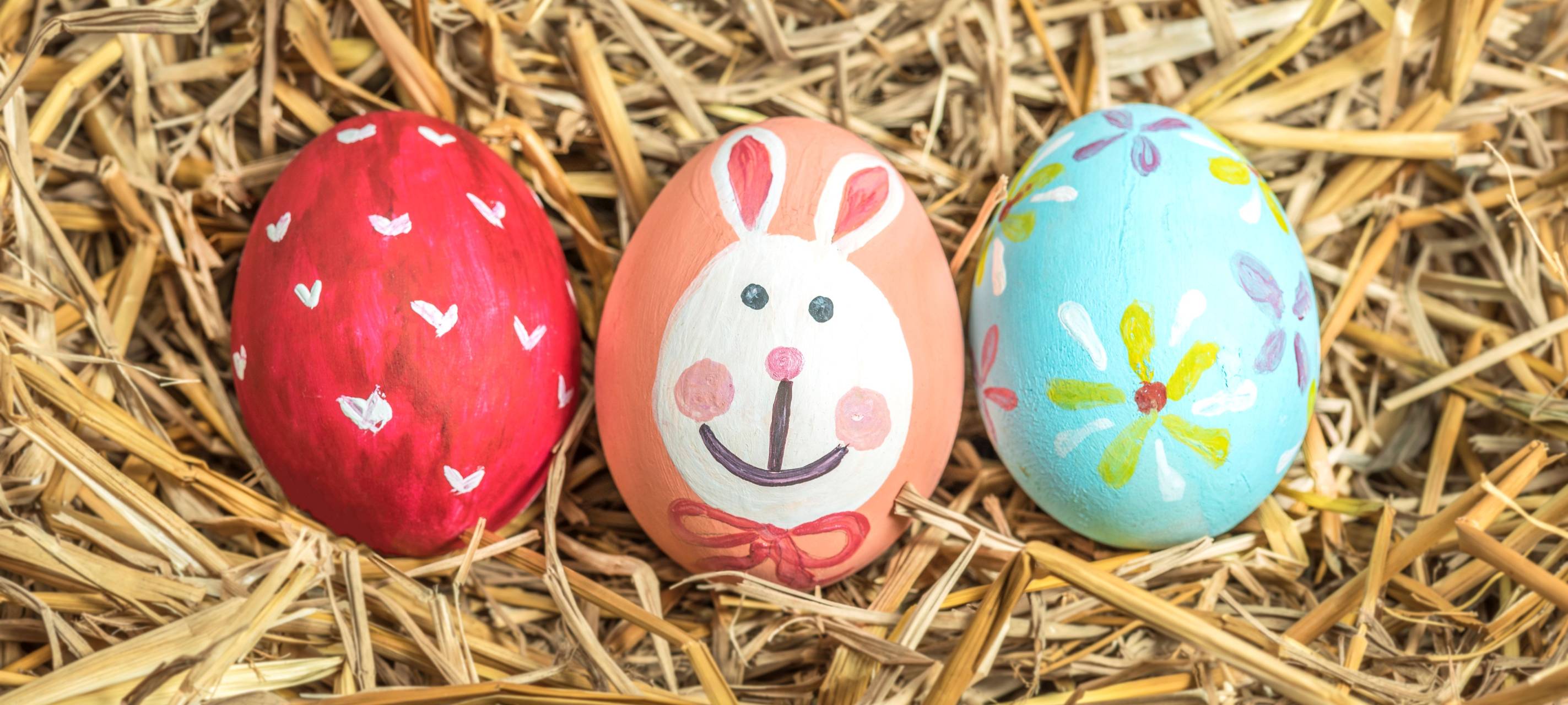 Drei bunte Ostereier im Stroh