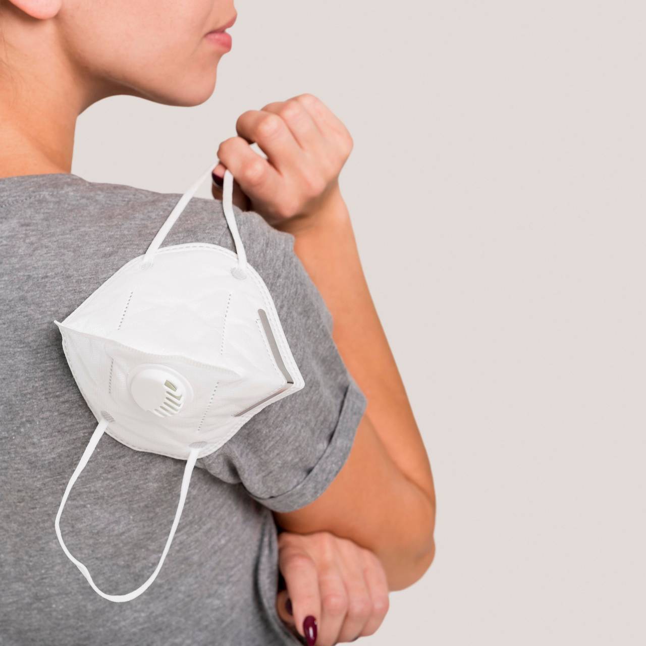 Frau hält FFP2 Maske in der Hand